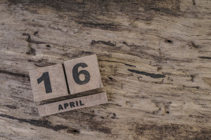 Cube calendar on wooden surface for april with copy space