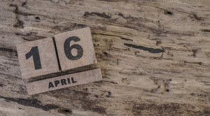 Cube calendar on wooden surface for april with copy space