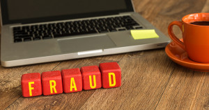 Fraud written on a wooden cube in a office desk