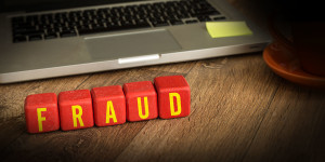 Fraud written on a wooden cube in a office desk