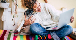 person on computer with dog