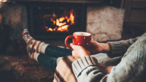 person with a mug sitting by the fire