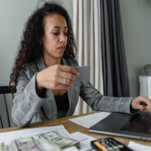 woman at desk holding credit card
