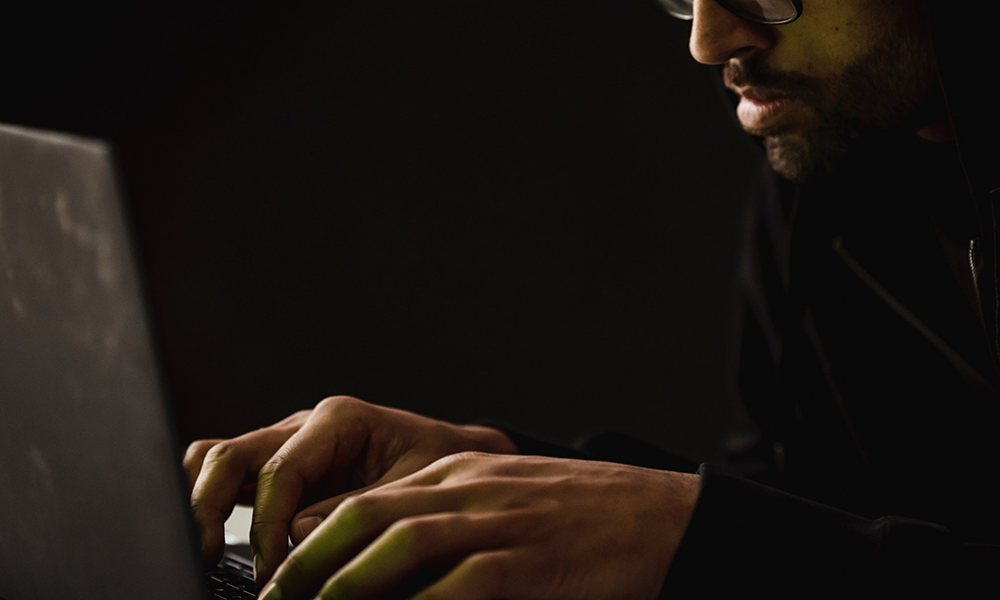 05.19.2021scam.pexels-man in shadows with laptop