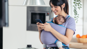 woman holding cell phone and infant