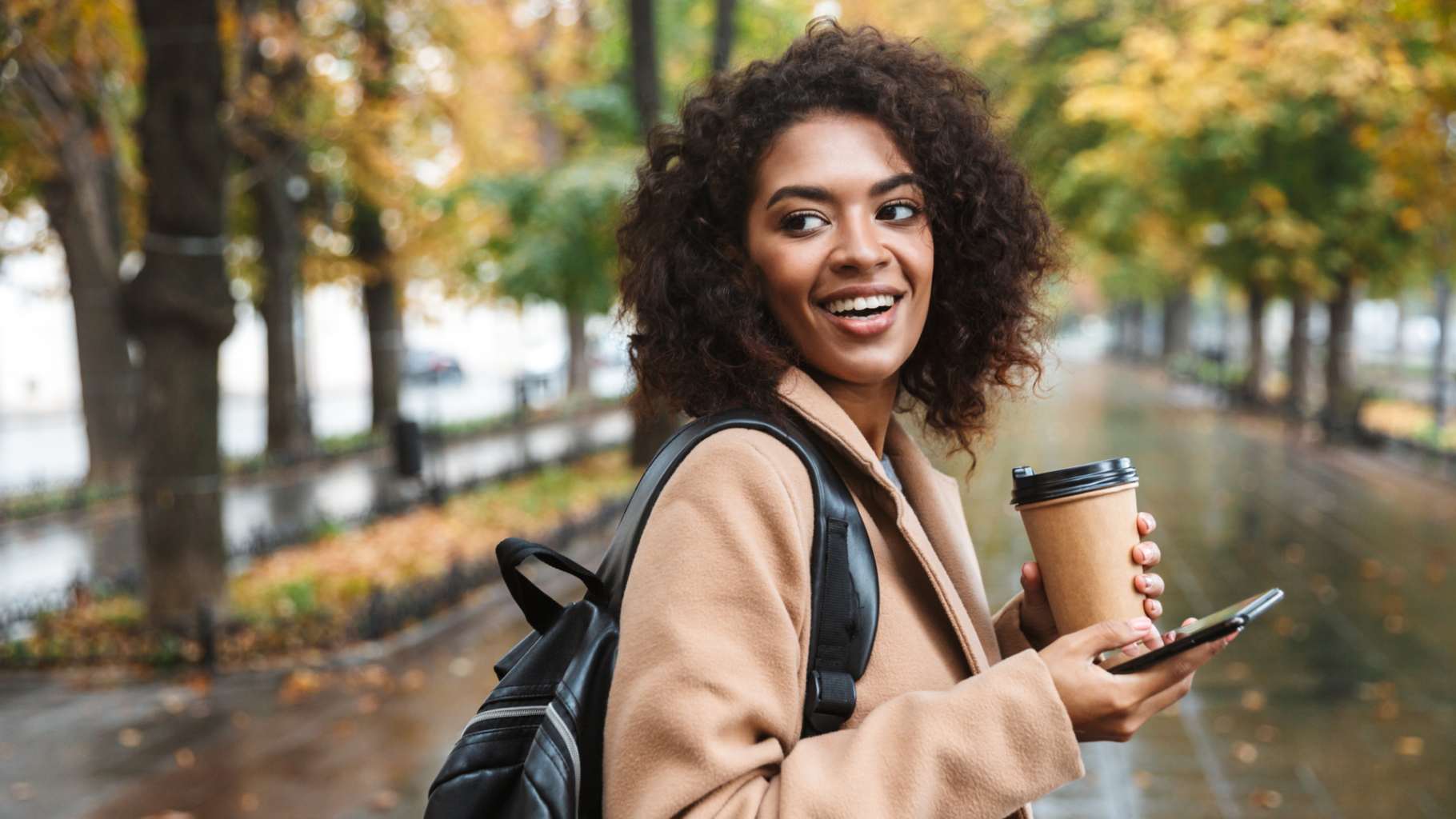 person on phone with coffee