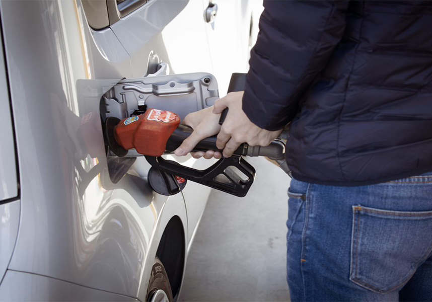 person pumping gasoline into silver vehicle